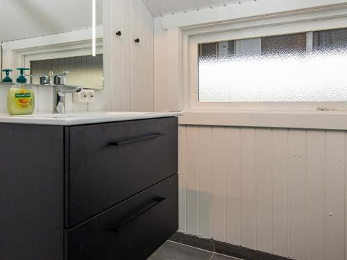 cocina con armarios negros, fregadero y ventana en Holiday home Egernsund X en Egernsund