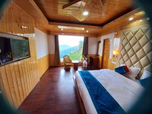 a bedroom with a large bed and a large window at Humble Holiday Home Kufri S H I M L A with Lawn and Amazing View in Kūfrī