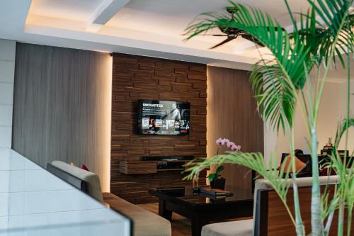 a living room with a tv on a brick wall at Villa Kayu Raja in Seminyak