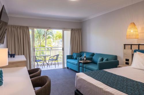 a hotel room with a bed and a couch and a patio at Tangalooma Island Resort in Tangalooma