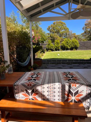 a bed sitting on a bench on a patio at holiday tiny house near park in Vermont South