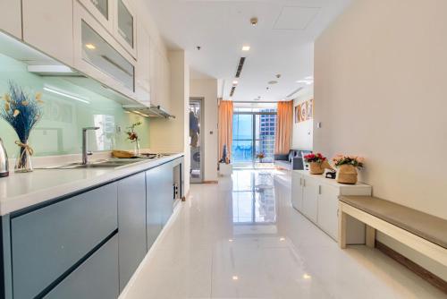 a large kitchen with white cabinets and a bench at MOTT HAVEN APART - Vinhomes Central Park, Landmark 81 Area & Ice Rink in Ho Chi Minh City