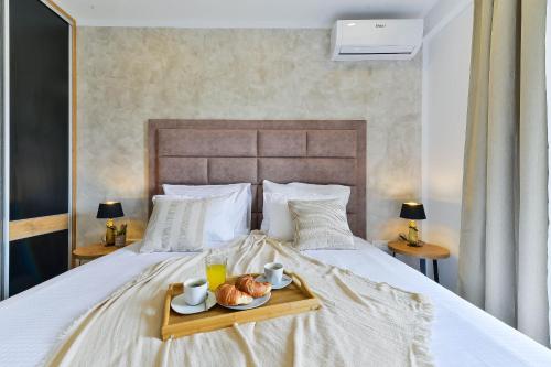 Una cama con una bandeja con dos tazas y cruasanes. en Villa Jomani, en Bibinje