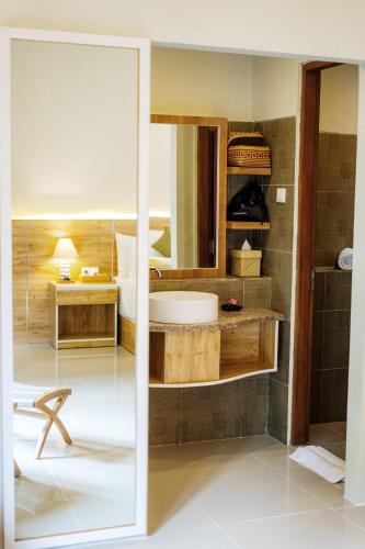 a bathroom with a tub and a sink at Tapa Tepi Kali Canggu in Canggu