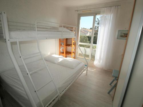 une chambre avec deux lits superposés et une fenêtre dans l'établissement Appartement à 150m de la plage, centre-ville, parking privé, équipé tout confort - FR-1-22-297, à La Tranche-sur-Mer