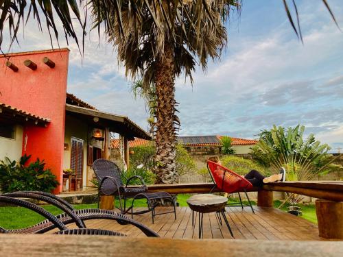 a woman laying on a porch with her feet on a chair at Rancho Recanto da Serra in Delfinópolis