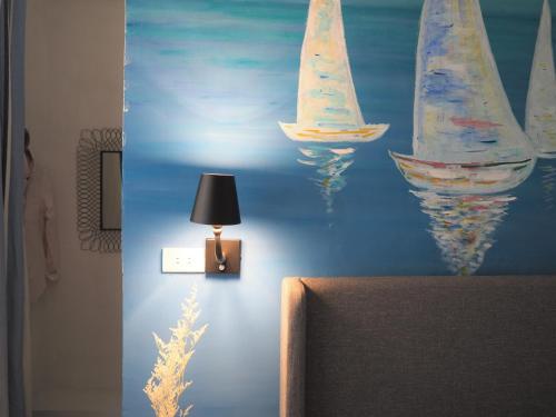 a room with a painting of sailboats on the wall at Seamoon House in Tainan