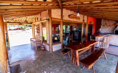 a dining room with a wooden table and chairs at Rancho Recanto da Serra in Delfinópolis