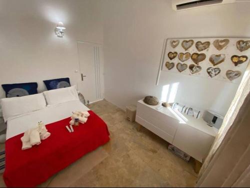 a bedroom with a bed with two teddy bears on a red blanket at Le Lantana by EGL IMMO in Le Marin