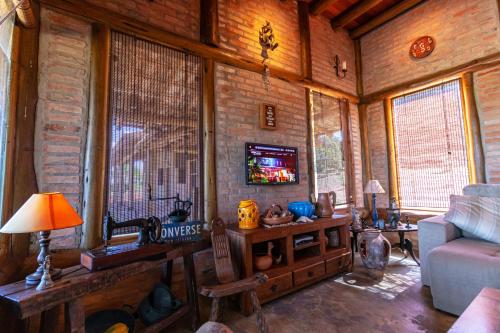 a living room with a couch and a tv at Rancho Recanto da Serra in Delfinópolis
