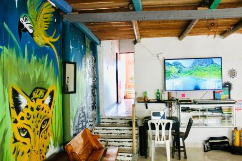 ein Wohnzimmer mit einem Wandgemälde in der Unterkunft Hostal Música y Arte in San Agustín