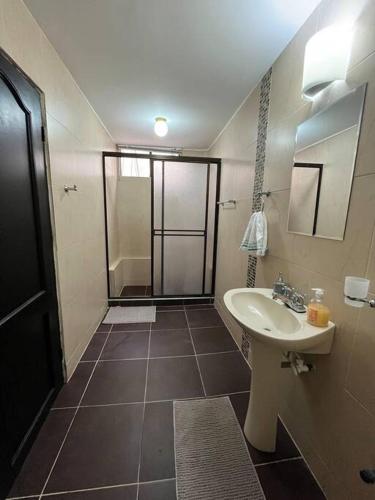 y baño con lavabo y ducha. en Acogedor apto para 8 zona buenavista, en Barranquilla