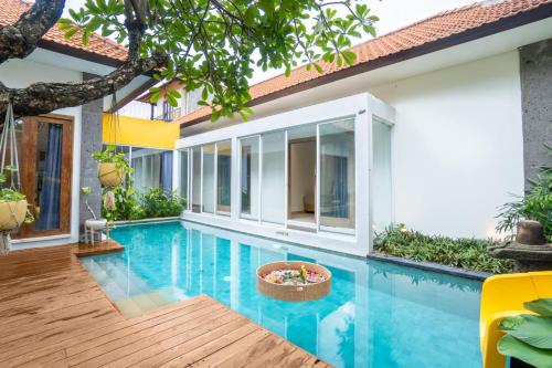 una piscina en una villa con una casa en La Mira Villa Seminyak by Ini Vie Hospitality, en Seminyak