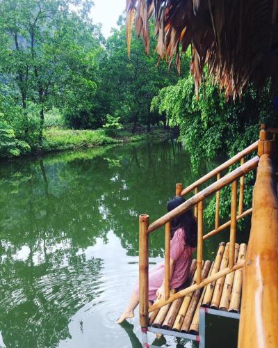 a woman sitting on a raft in the water at Hang Lan Bungalow in Ninh Binh