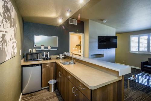 a small kitchen with a sink and a microwave at Lions Gate Hotel in Sacramento