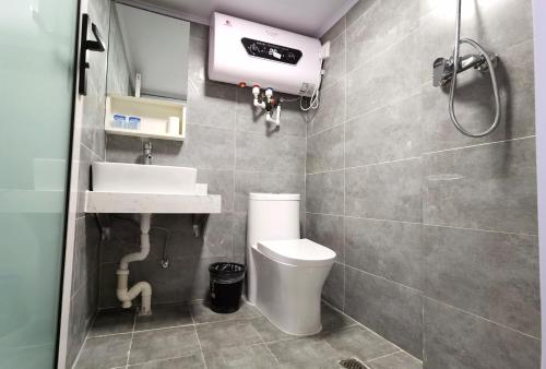 a bathroom with a sink and a toilet at Happy Dragon Hotel -- Nearby Tiananmen square & Forbidden City & Line 5,6,8 Subway Nearby & Free coffee & Free laundry & Fluent English speaking& Tourist attractions ticket service & Free WiFi unlimited for Western software, Shuttle bus to the Great Wall in Beijing