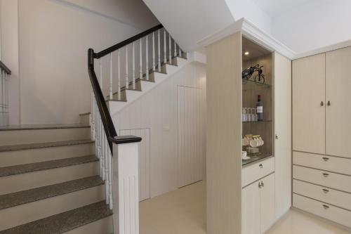 a staircase in a home with white walls and white cabinets at Creekside No.22 B&B in Jiali