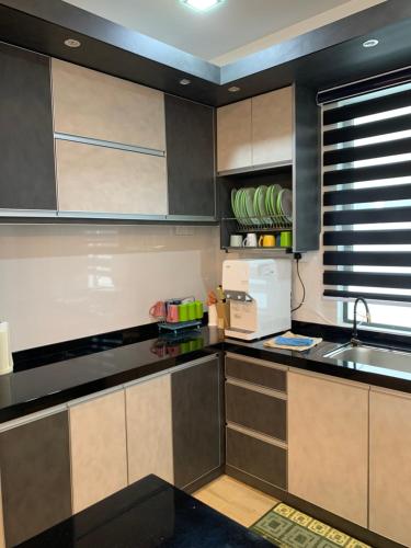 a kitchen with brown and white cabinets and a sink at Barakah Homestay @ Meru Casa Kayangan in Ipoh