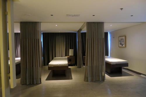 ein Hotelzimmer mit 2 Betten und Vorhängen in der Unterkunft Uptown BGC Taguig - One Bedroom in Manila