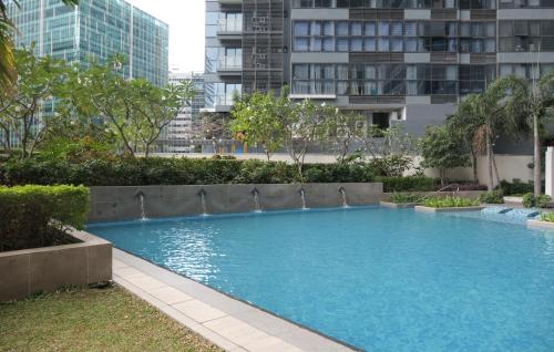 ein großes Schwimmbad in einer Stadt mit hohen Gebäuden in der Unterkunft Uptown BGC Taguig - One Bedroom in Manila