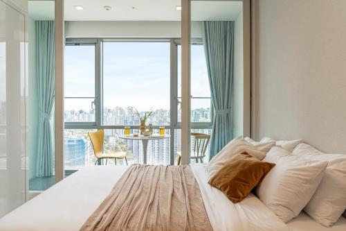 1 dormitorio con cama y ventana grande en Urbanstay Dongtan, en Hwaseong