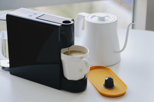 a coffee maker is making a cup of coffee at Urbanstay Residence Dongtan in Hwaseong