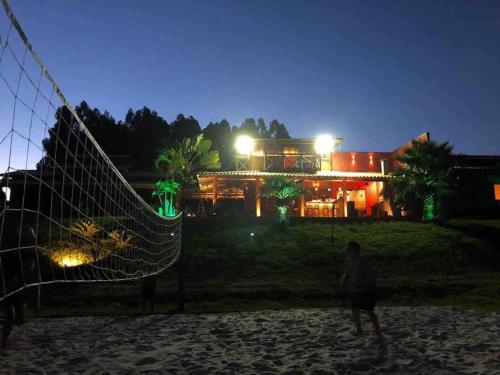 a person standing in front of a house at night at Rancho Recanto da Serra in Delfinópolis