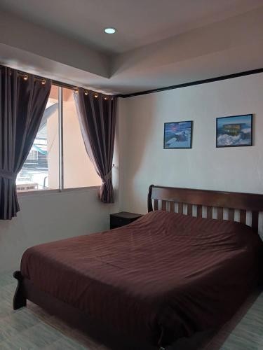 Un dormitorio con una cama grande y una ventana en Kalisa House@Soi welcome en Jomtien Beach
