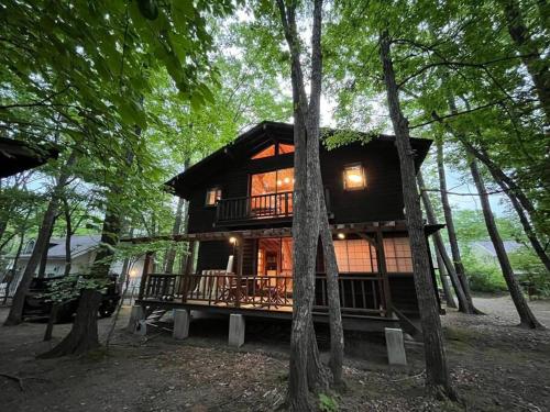 a log cabin in the woods with trees at 貸し別荘 Key of Private Villa 'ムササビハウス' in Kita-karuizawa