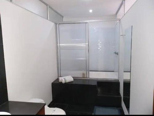 uma casa de banho com uma cabina de duche em vidro e um WC. em Apartamento Cali-Granada Piscina em Cali
