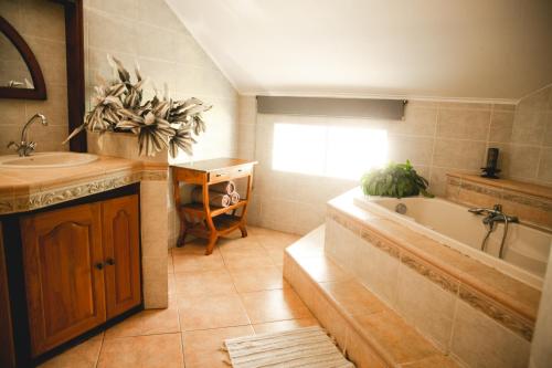 La salle de bains est pourvue d'une baignoire, d'un lavabo et d'une baignoire. dans l'établissement LE COLONIAL, T4 à 5 mn Aeroport dans villa de standing, à Sainte-Marie