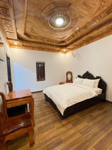 a bedroom with a bed and a wooden ceiling at Hotel Hoàng My in Pleiku