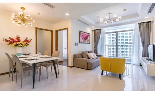 a dining room and living room with a table and chairs at Vinhome Central Park Apartment - LandMark 81 in Ho Chi Minh City