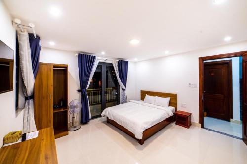 a bedroom with a bed and blue curtains at Đà Lạt Cao Nguyên Hotel in Da Lat