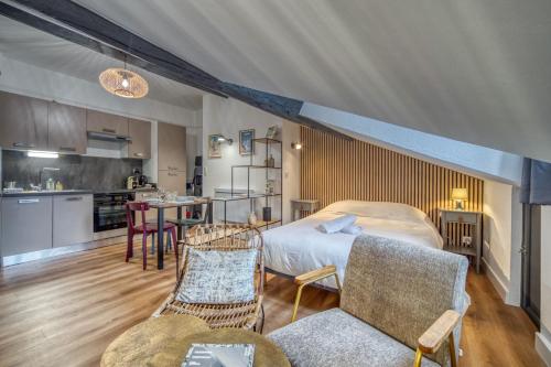 une chambre avec un lit et une cuisine avec une table dans l'établissement Le Strasbourg - Centre ville - Climatisation, à Grenoble