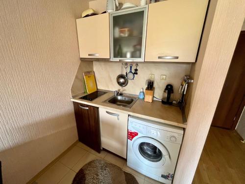 a small kitchen with a washing machine and a sink at Julia Vigo Panorama apartments in Nesebar