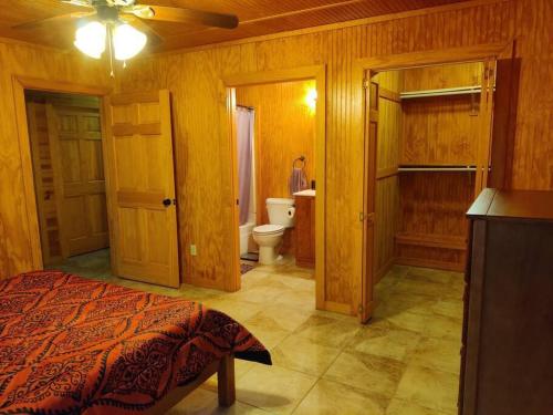 a bedroom with a bed and a bathroom with a toilet at Quiet cabin near Enid Lake in Enid