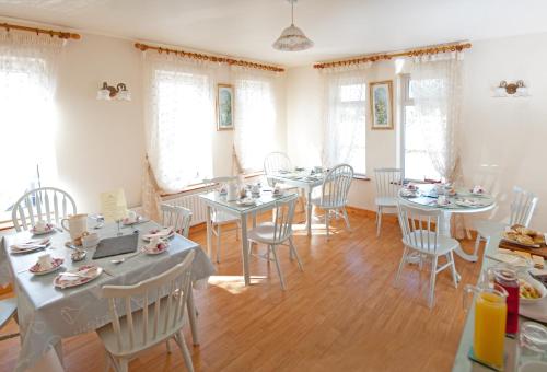 a dining room with tables and chairs and windows at Tower Lodge B&B in Mallow
