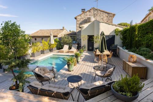 an outdoor patio with chairs and a swimming pool at MAISON BELLEVUE DE SAGRIES in Sagriès