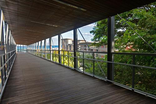 a wooden walkway with a view of a building at High-Rise Modern Oasis with Pool and City Views in Darwin