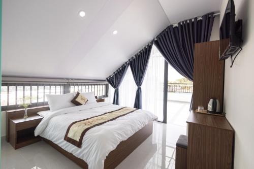 um quarto com uma cama e uma grande janela em Happy Home Da Lat em Da Thanh