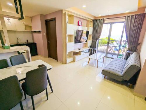 a living room with a couch and a table and chairs at Lovina 909 Harbour Bay Residence in Batu Ampar