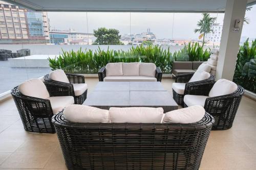 a patio with wicker chairs and a table on a balcony at Lovina 909 Harbour Bay Residence in Batu Ampar