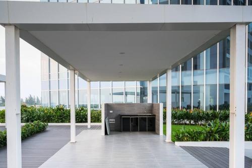 a large glass building with a fireplace in the middle at Lovina 909 Harbour Bay Residence in Batu Ampar
