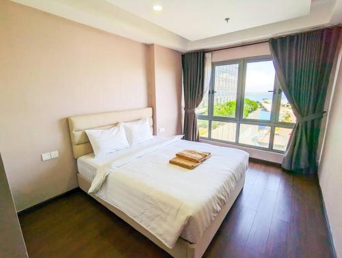 a bedroom with a bed and a large window at Lovina 909 Harbour Bay Residence in Batu Ampar