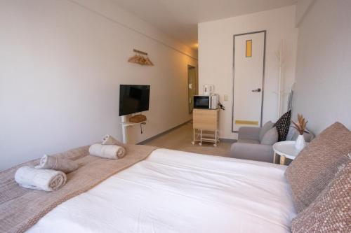 um quarto com uma grande cama branca e uma sala de estar em gaojin 第2高津グローリーハイツ em Osaka