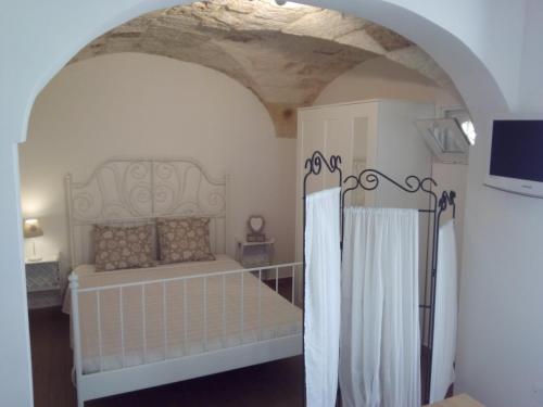 a bedroom with a bed and a tv in a room at House Rental for Tourists in Monopoli