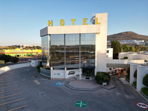 un hôtel avec un panneau au-dessus d'un bâtiment dans l'établissement Hotel Alcampo, à Querétaro