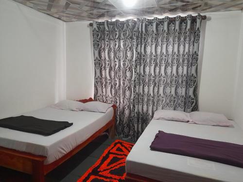 オヒヤにあるOhiya Jungle resortのベッド2台とカーテンが備わる客室です。