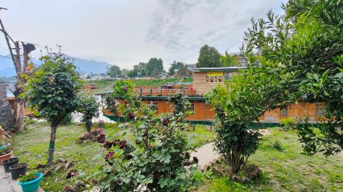 a garden with trees and a building in the background at Houseboat Karima palace in Srinagar